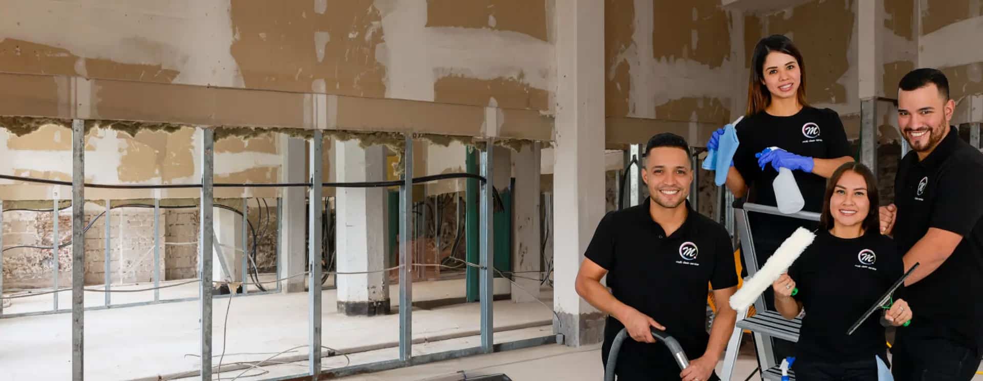 Vier Mitarbeitende von Multi Clean Service mit Sauger, Sprühflasche und Fensterwischer in einem Rohbau mit unverputzten Wänden