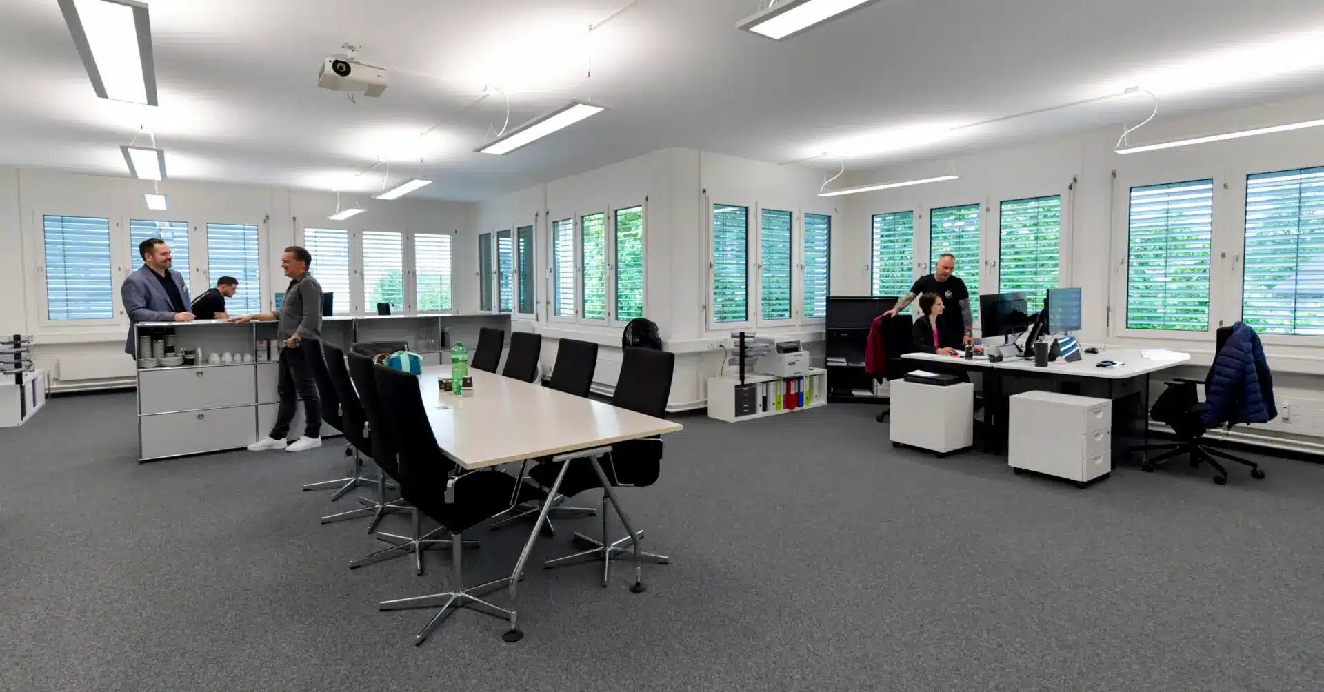 Das Büro von Multi Clean Service in Fehraltorf — fünf Mitarbeitende an Sitzungstisch und Arbeitsplätzen