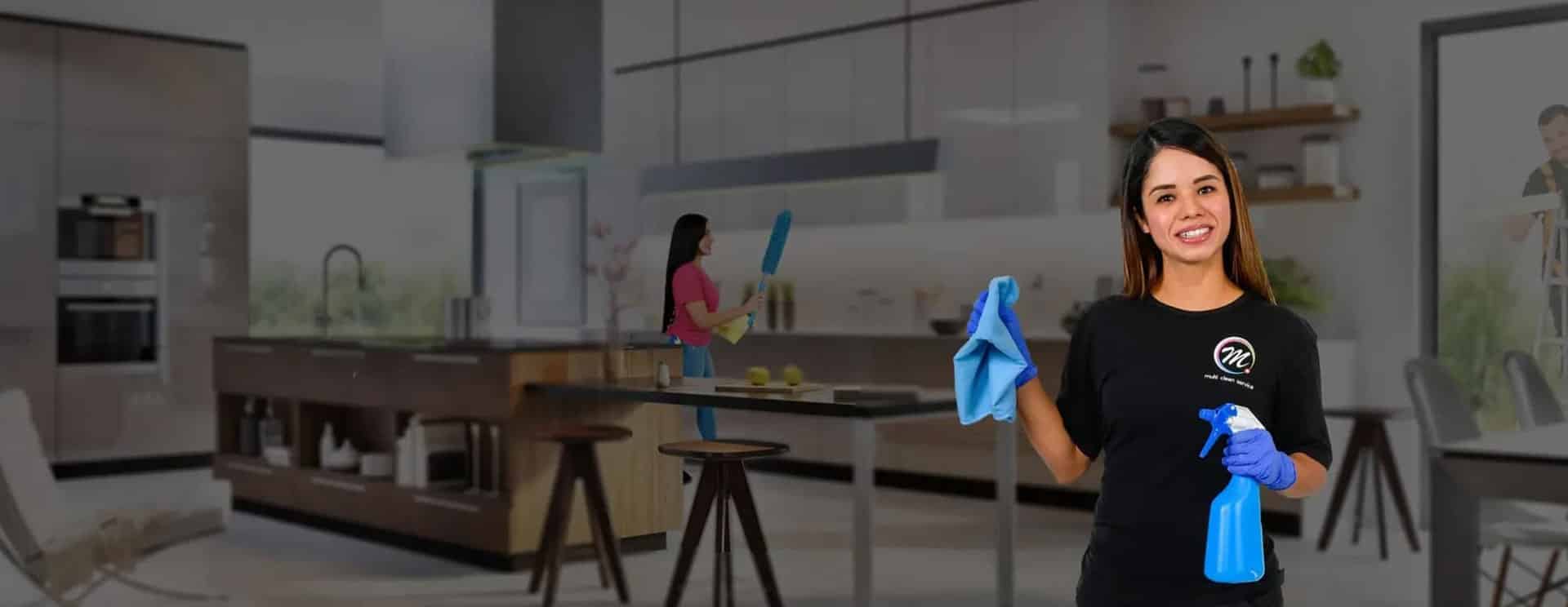 Zwei Mitarbeiterinnen von Multi Clean Service in einer offenen Wohnküche, eine mit Tuch und Sprühflasche, eine mit Staubwedel